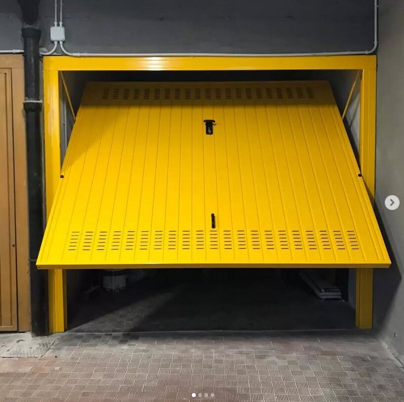 Tecnico che regola una porta basculante di un box auto